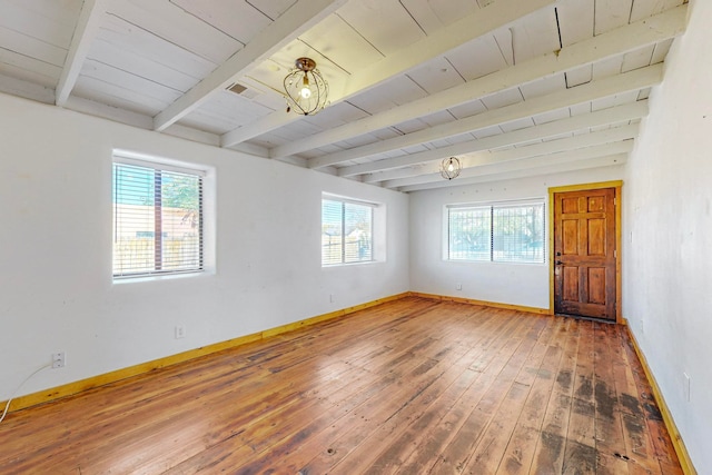 unfurnished room with beamed ceiling, a wealth of natural light, hardwood / wood-style flooring, and wooden ceiling