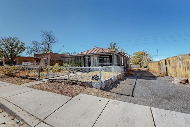 view of front facade with fence private yard and a sunroom