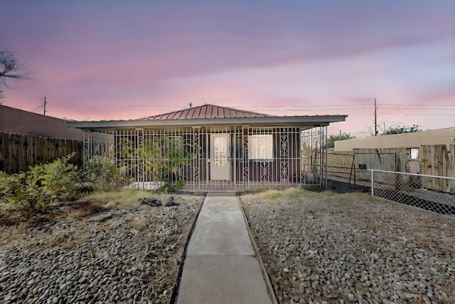 view of front of home with metal roof and fence