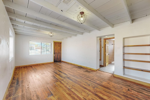 spare room featuring hardwood / wood-style flooring, beamed ceiling, and baseboards