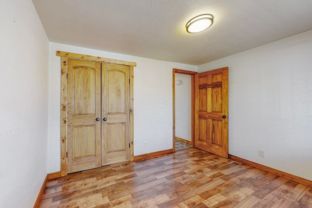 unfurnished bedroom featuring light wood-type flooring and a textured ceiling