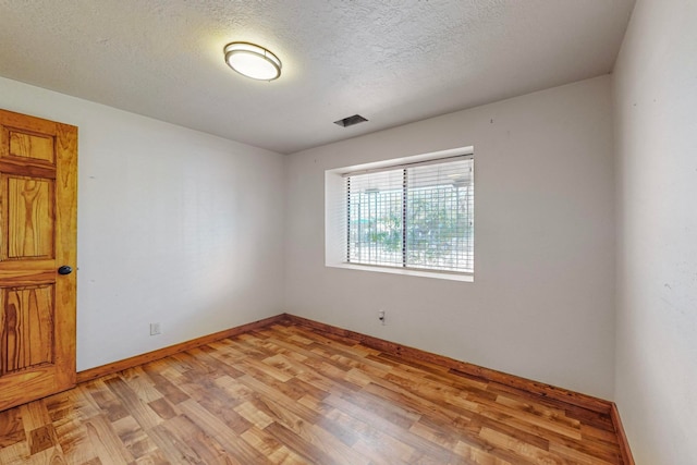 empty room featuring light hardwood / wood-style flooring and a textured ceiling