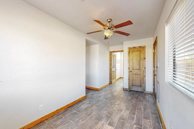 unfurnished room featuring dark wood-type flooring and ceiling fan