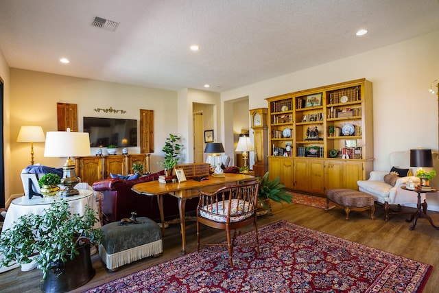 living room with a textured ceiling and wood-type flooring