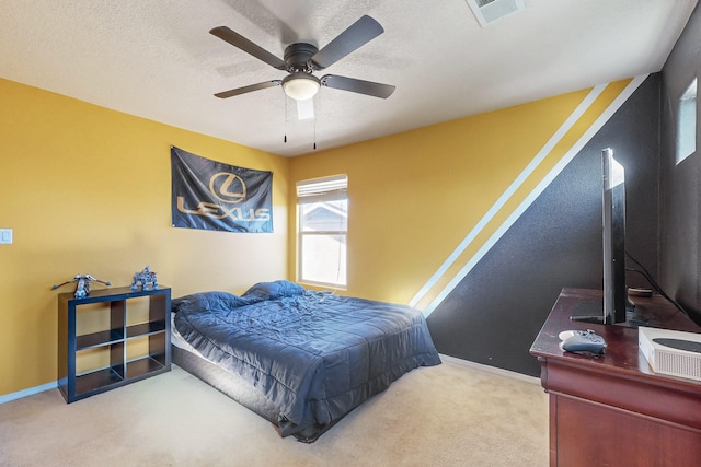 carpeted bedroom with ceiling fan and a textured ceiling