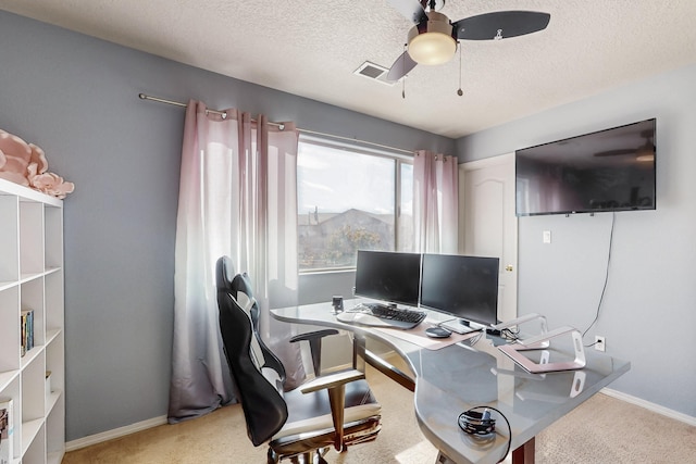 office space featuring ceiling fan, light colored carpet, and a textured ceiling