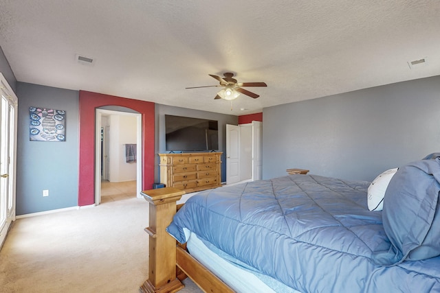 carpeted bedroom with ceiling fan and a textured ceiling