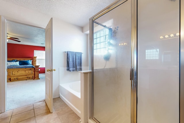 bathroom with tile patterned floors, ceiling fan, separate shower and tub, and a textured ceiling