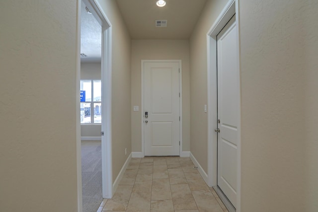 corridor featuring light tile patterned floors