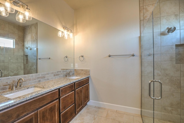 bathroom featuring tile patterned floors, backsplash, vanity, and a shower with shower door