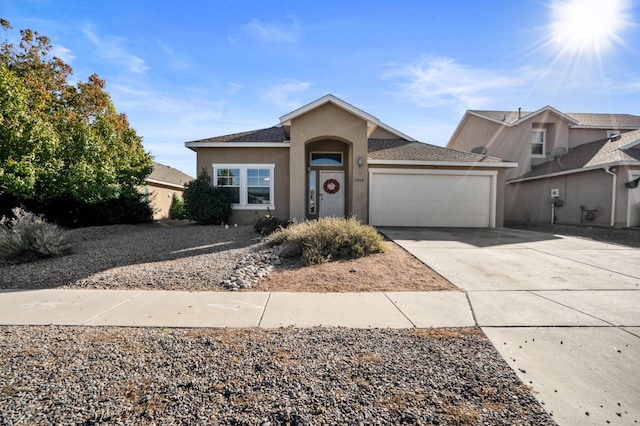 view of front facade featuring stucco siding, driveway, a shingled roof, and a garage