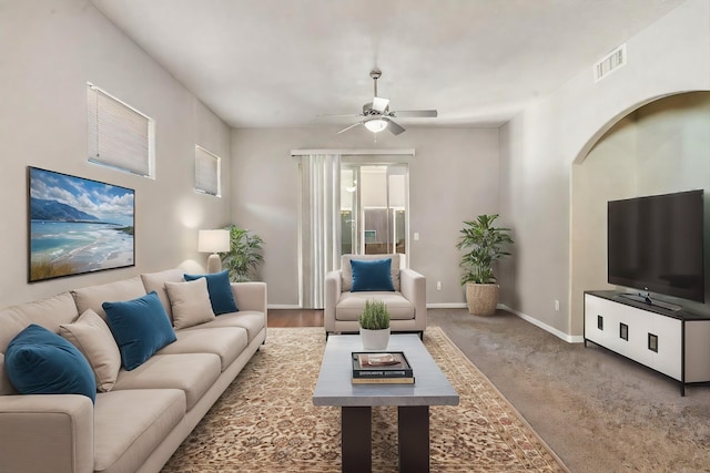 living area with visible vents, ceiling fan, baseboards, and carpet floors