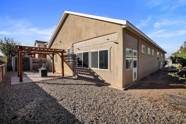 back of property with a pergola, a fenced backyard, an outdoor structure, a patio area, and a storage unit