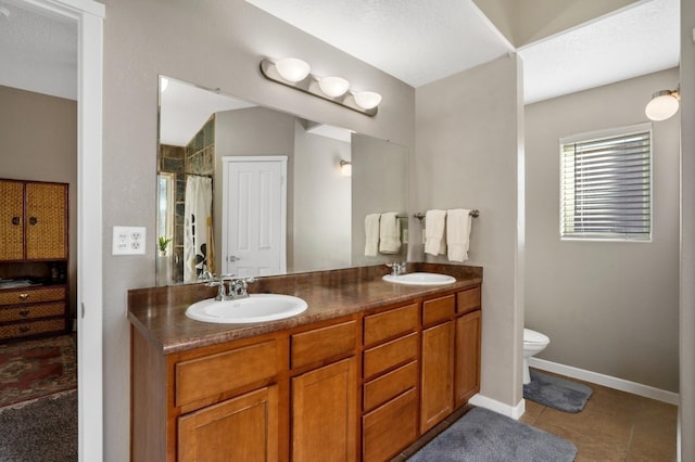 bathroom featuring vanity, tile patterned flooring, a shower with shower curtain, toilet, and a textured ceiling