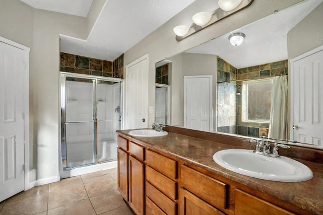 full bathroom featuring a sink, a shower stall, and tile patterned flooring