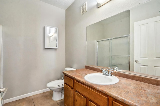 full bath featuring tile patterned floors, toilet, a shower stall, baseboards, and vanity