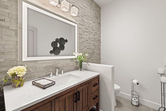 bathroom with decorative backsplash, vanity, and toilet