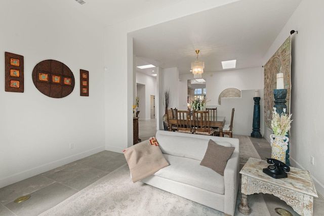 living room featuring a skylight and a notable chandelier