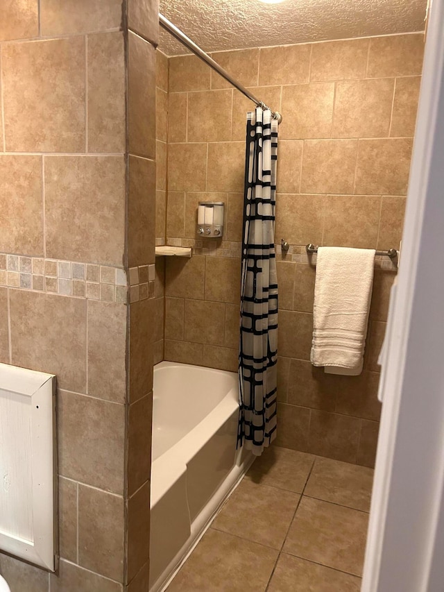 bathroom with a textured ceiling, tile patterned floors, and shower / tub combo with curtain