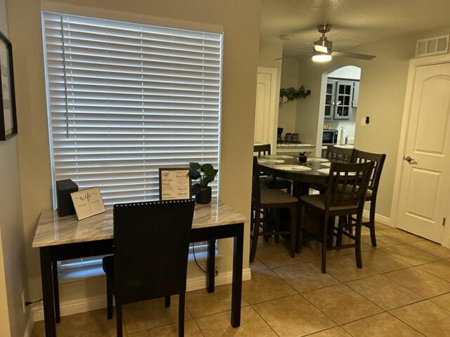 tiled dining space featuring ceiling fan