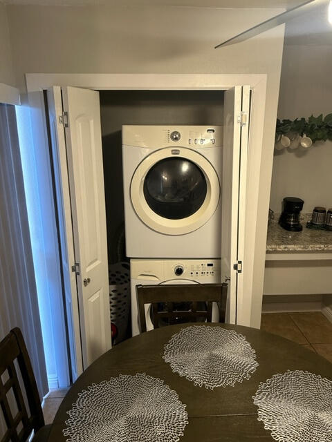 laundry area with tile patterned floors and stacked washer / drying machine