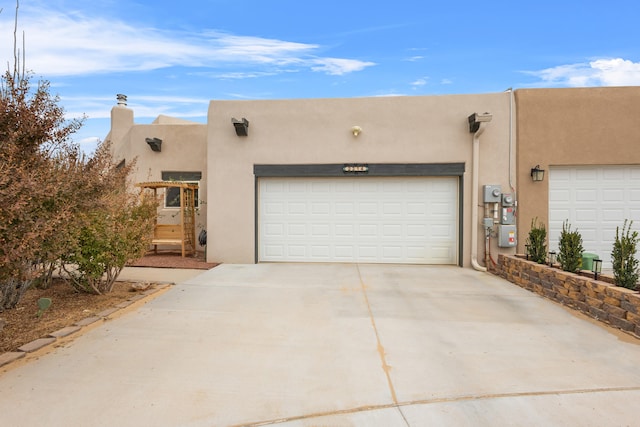 pueblo-style house featuring a garage