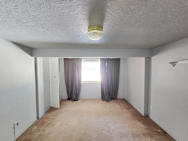 carpeted empty room featuring a textured ceiling