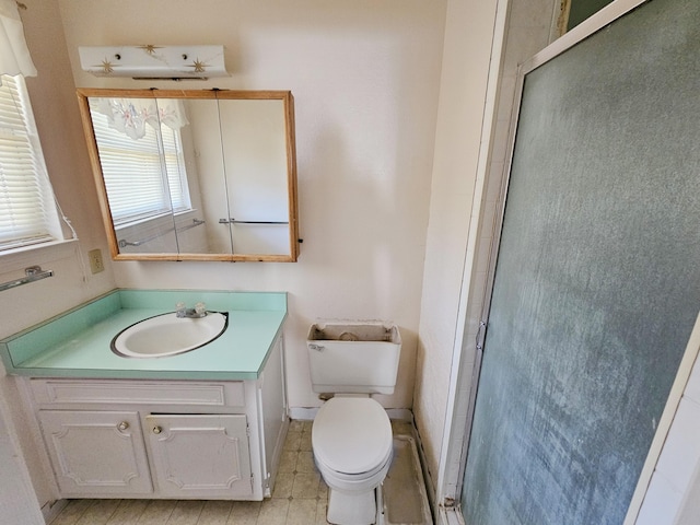 bathroom with a notable chandelier, vanity, toilet, and a shower with shower door