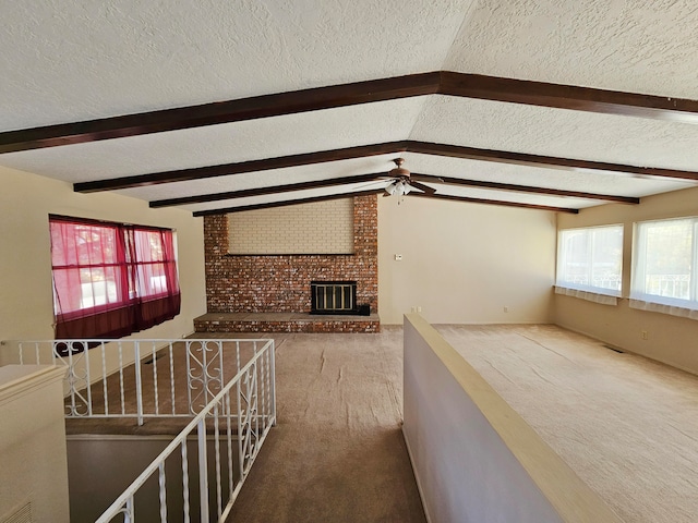 hallway with carpet, vaulted ceiling with beams, and a textured ceiling