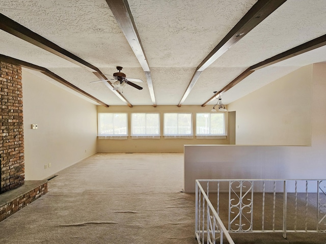 unfurnished living room featuring lofted ceiling with beams, a textured ceiling, carpet floors, and ceiling fan