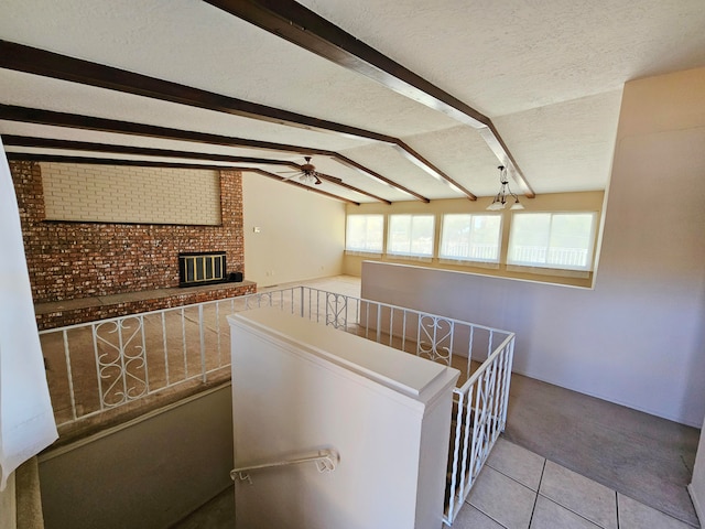 hallway with vaulted ceiling with beams, light tile patterned floors, a textured ceiling, and an inviting chandelier