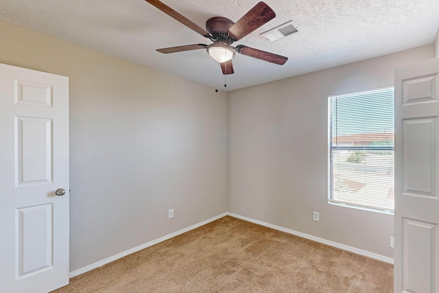 carpeted spare room with ceiling fan and a textured ceiling