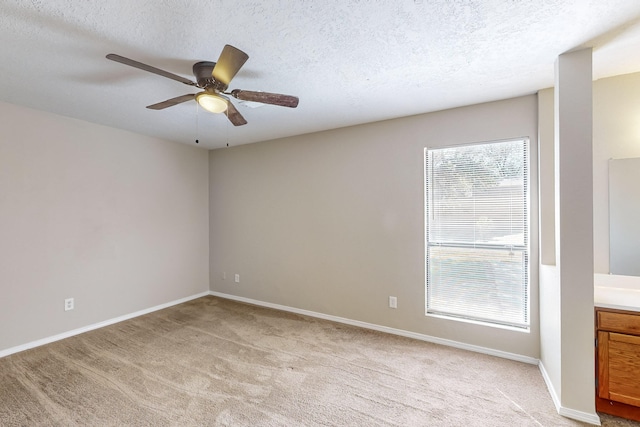 carpeted spare room with a textured ceiling and ceiling fan