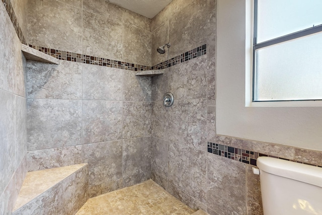 bathroom with tile walls, toilet, and tiled shower