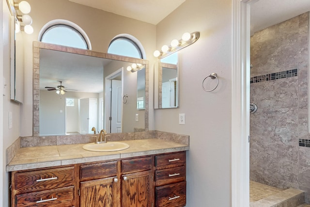 bathroom featuring ceiling fan, vanity, and a tile shower