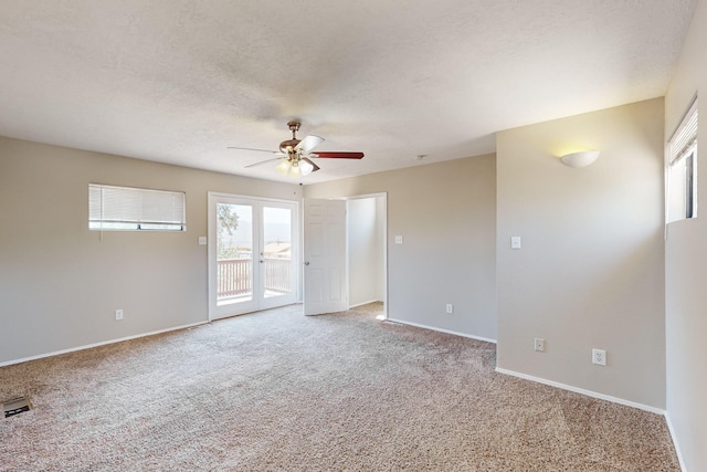 carpeted spare room featuring ceiling fan and a textured ceiling