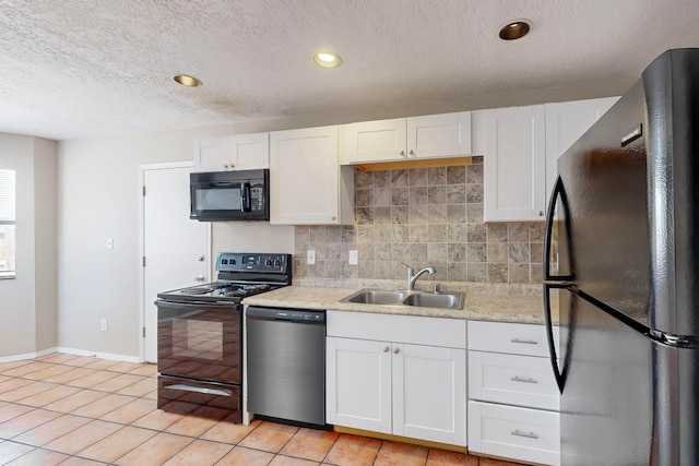 kitchen with white cabinetry, sink, black appliances, and tasteful backsplash