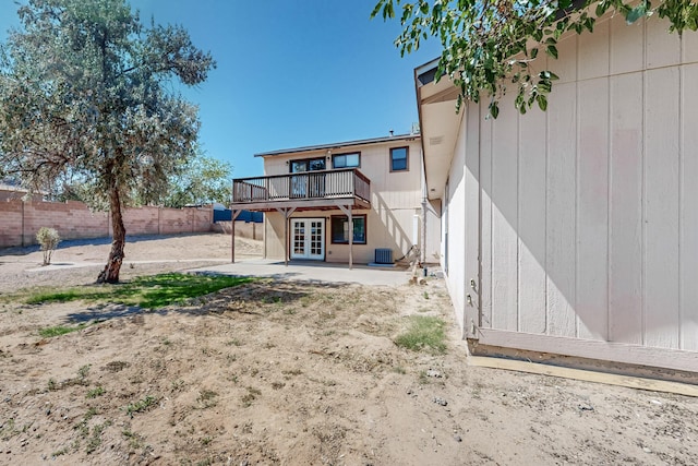 rear view of house with a deck, cooling unit, french doors, and a patio area