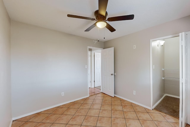 unfurnished bedroom featuring ceiling fan, light tile patterned floors, and a closet