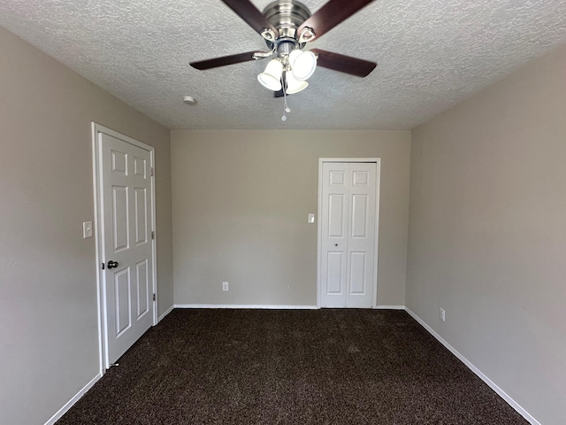 empty room with ceiling fan, carpet floors, and a textured ceiling