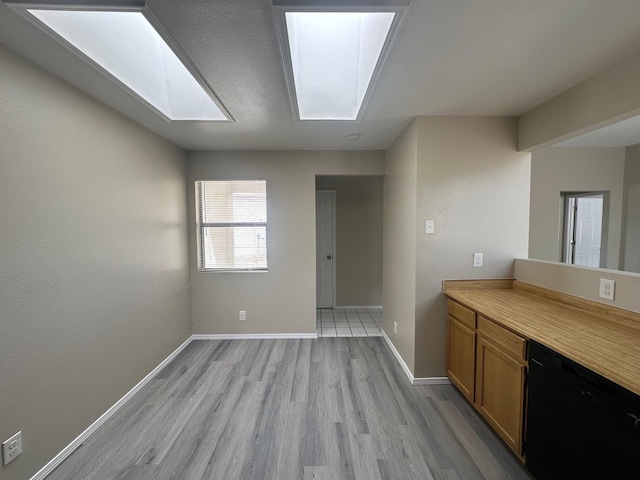 kitchen with a skylight and light hardwood / wood-style flooring