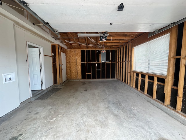 misc room with concrete flooring and electric panel