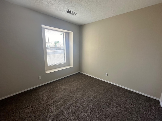 carpeted empty room featuring a textured ceiling