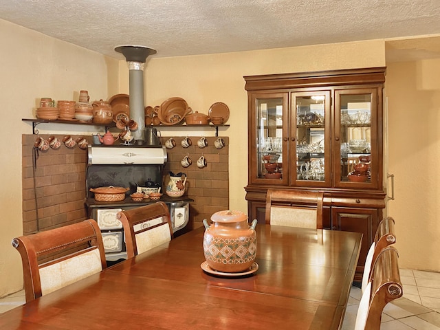 tiled dining room with a wood stove and a textured ceiling