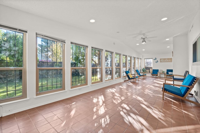 unfurnished sunroom with a wealth of natural light, lofted ceiling, and ceiling fan