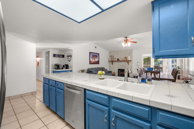 kitchen featuring blue cabinetry, dishwasher, and tile counters