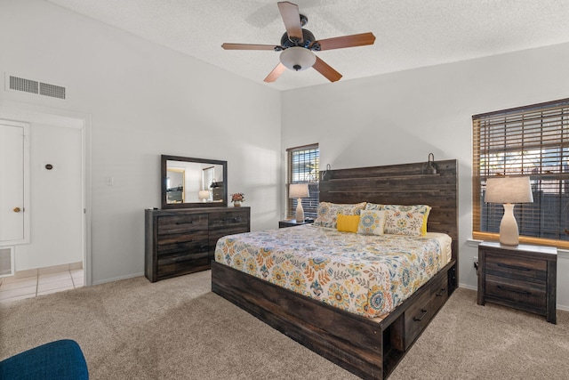 carpeted bedroom with multiple windows, ceiling fan, and a textured ceiling