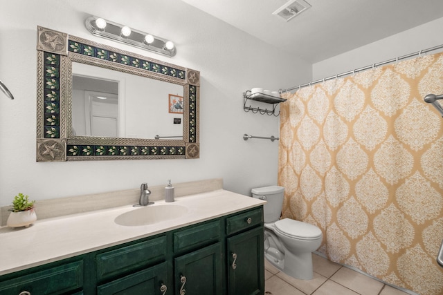 bathroom with toilet, vanity, and tile patterned floors