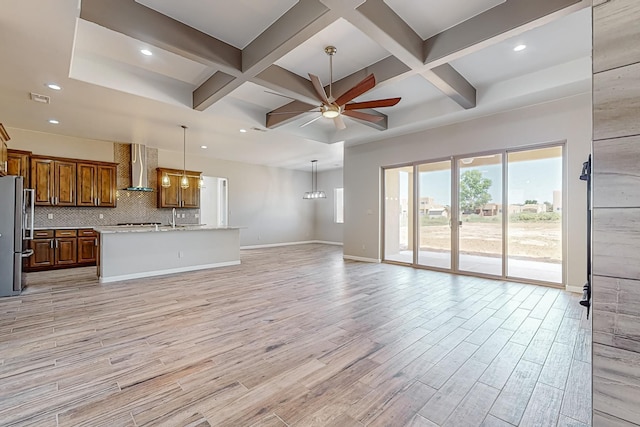 unfurnished living room featuring beam ceiling, light wood-type flooring, and coffered ceiling