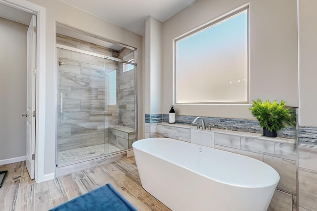 bathroom featuring hardwood / wood-style floors and independent shower and bath